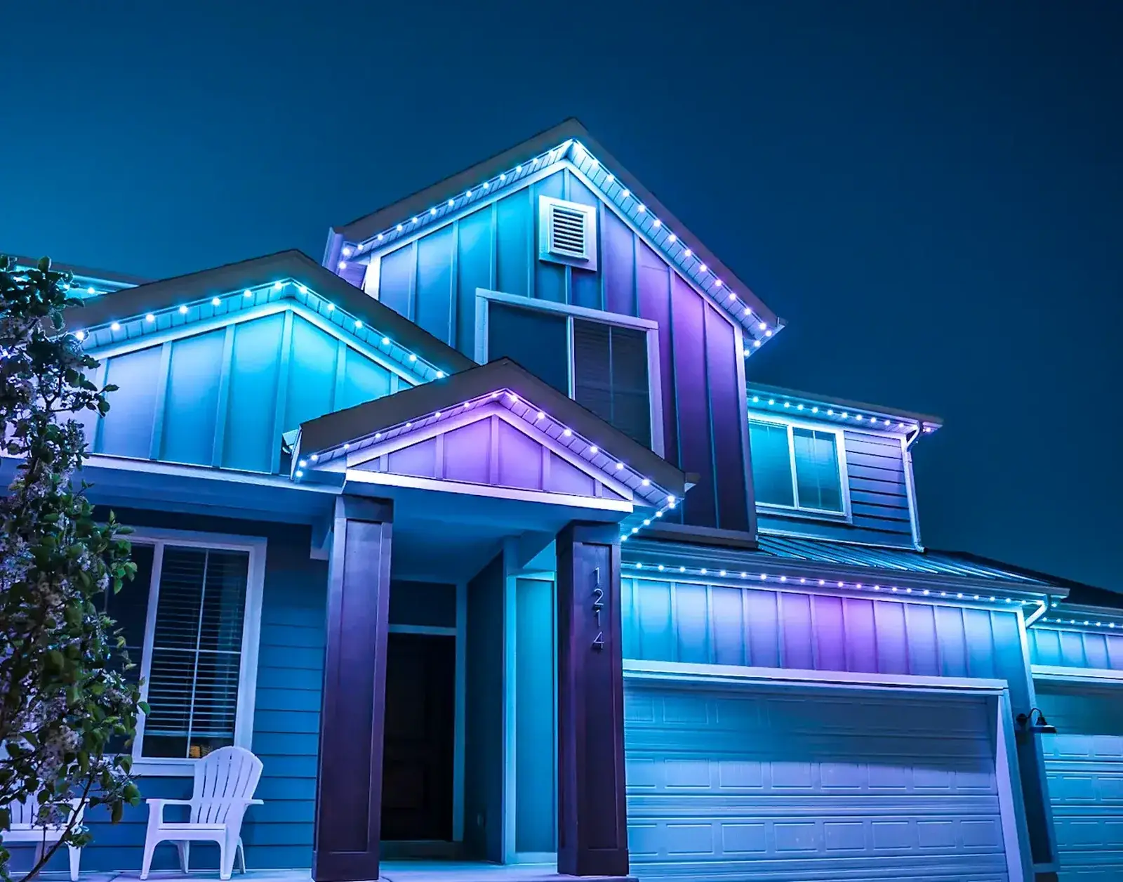 jellyfish-lighting-color-roofline-memphis-wide - Precision Pools Landscape - Precision Pools Landscape Permanent LED lighting on a two story home at night, running blue and purple colour along the rooflines, gables and garage